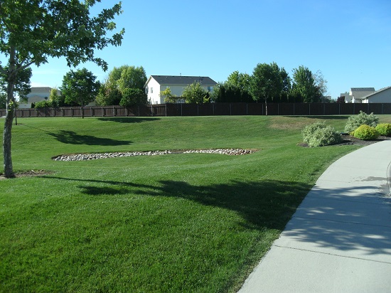 Paved sidewalk beside grassy knoll